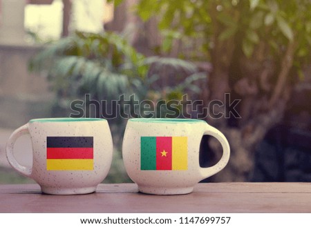 Germany and Cameroon Flag on two tea cups with blurry background