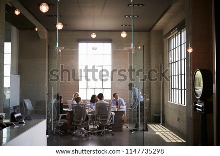 Business colleagues at a meeting in a glass walled boardroom Royalty-Free Stock Photo #1147735298