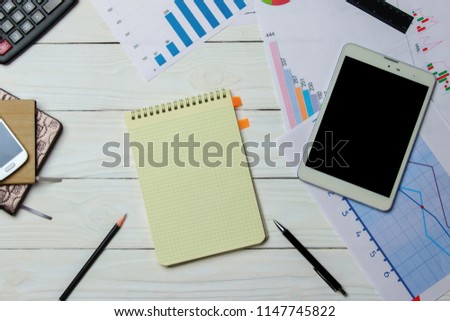 Office Desk with charts, calculator, tablet and notebook. Top view with copy space.