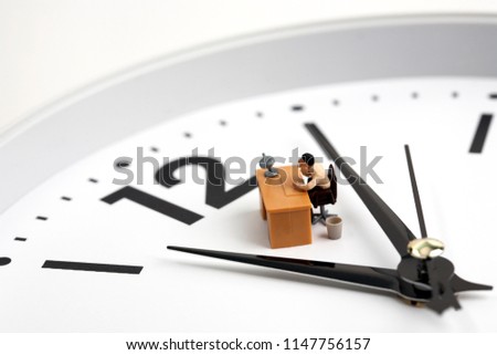Miniature man working on clock background