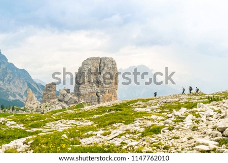 Hiking in the mountains. Cinque Torri Five  Towers at the Heart of the Italian Dolomites. Young people doing trekking excursion. Travelers in the highlands. Tourists walking along mountain meadow path