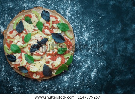 Pizza cooked in a pan with tomato ham and cheese on a dark background