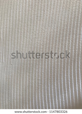Vertical thin shadow lines on a white wall
