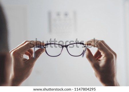 patient is holding glasses for vision. Vision tests at  hospital. focus on  glasses