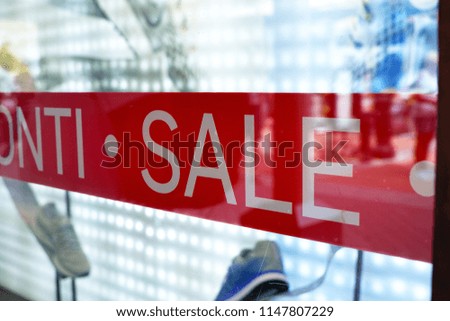 Advertising of the annual period of discounts in the store, information about sale in glass shop window with reflection of people and shopping mall
