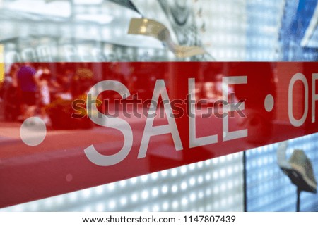 Advertising of the annual period of discounts in the store, information about sale in glass shop window with reflection of people and shopping mall
