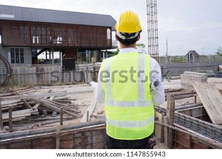 Close up engineers working on a building site holding a blueprints