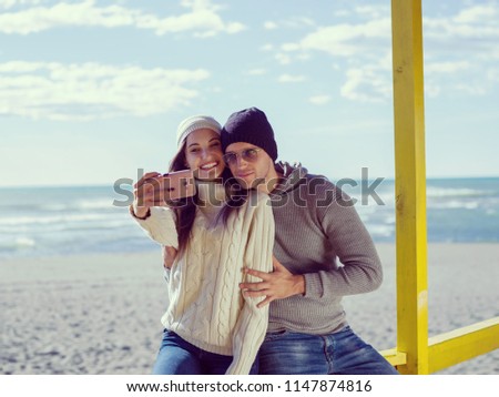 Very Happy Couple In Love Taking Selfie On The Beach in autmun day colored filter