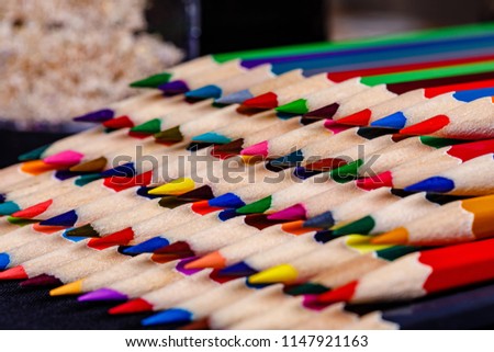 Colored Pencils stacked neatly in a random color pattern but in a very OCD fashion ready for use by students or artists.
