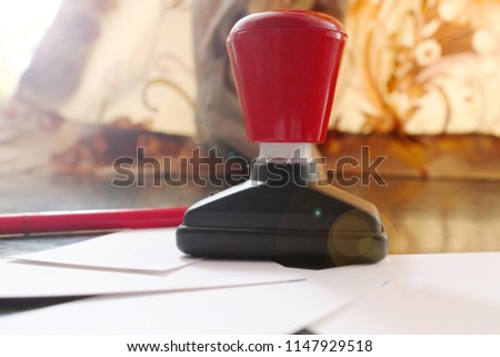 Office paper document stamp with Business cards, papers and red pen lying around.