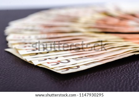 Pile of several euro banknotes on leather background