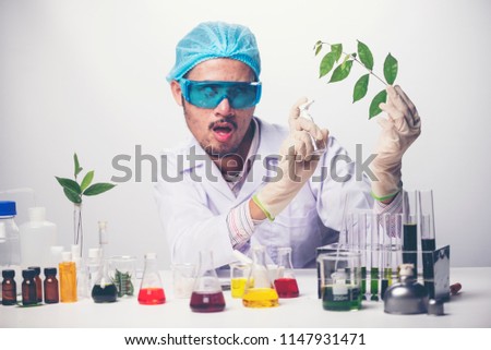 Crazy scientist pours the liquid from a tube to other tube doing an experiment with creepy face emotion, isolated on a white background.