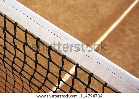 Clay tennis court and a tennis net.