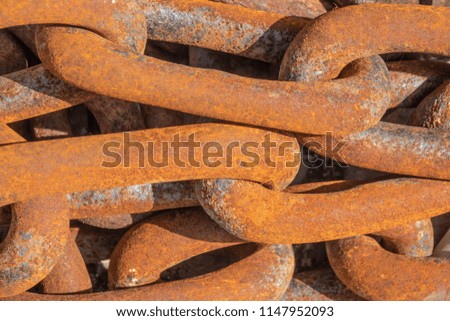 The links of a large iron rusty chain .