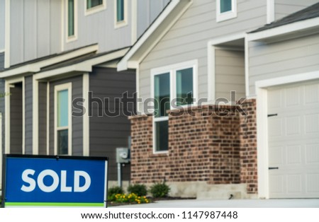 New home development houses on the market are now Sold. Sold sign in front of nice modern brick home just built. Sold sign in corner of image with room for text and background