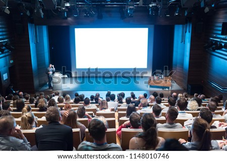 Business and entrepreneurship symposium. Speaker giving a talk at health care workshop meeting. Audience in conference hall. Rear view of unrecognized participant in audience. Royalty-Free Stock Photo #1148010746