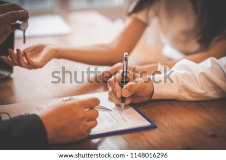 
Businessmen are holding a pen signing a contract on paper.
