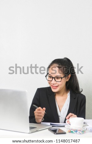 Happy business Asian woman working with laptop at white working table, diligent professional working woman.