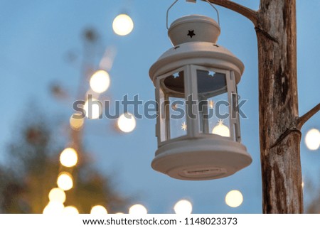 white candle lantern with summer terrace background. Bokeh