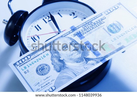Time to make money. Alarmclock with Dollars cash as symbol of business, wealth and work.