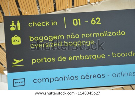 Portuguese airport information board / signage. Signs for gates, departures, security, arrivals, check in.
