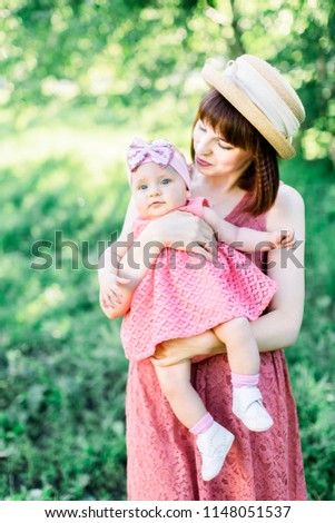 Young mother with her little baby on the meadow