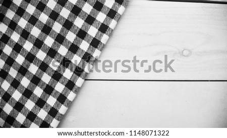 Wooden table covered with tablecloth cloth checkered. black and white
