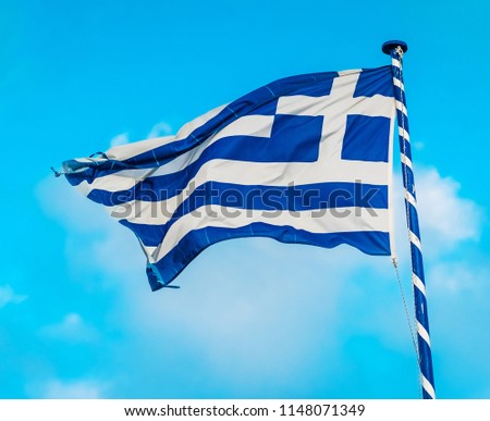 Greek flag on the flagpole under blue sky