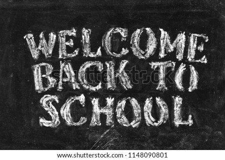 Back to school background. "WELCOME BACK TO SCHOOL" white chalk text on school blackboard.
