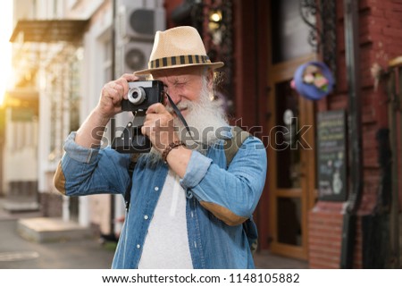 Happy smiling mature man keeping device