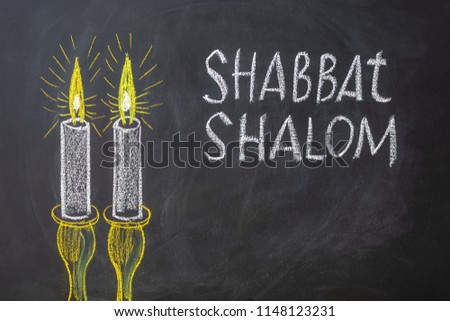 Jewish greetings Shabbat Shalom and candles painted on a chalkboard. May you dwell in completeness on this seventh day.