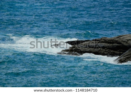 Selective close up Stone in sea with wave on sunset time background, sea,water,rock.