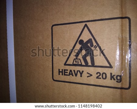 Warning heavy object sign it's over 20kg., Careful do not lift,Capture on carton by night shot. Handling mark on craft paper background. Can be used on a box or packaging. Royalty-Free Stock Photo #1148198402