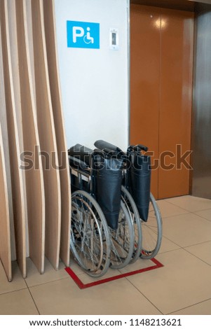 Wheelchair and elevator for disabled, wheelchair waiting in front of elevator in building