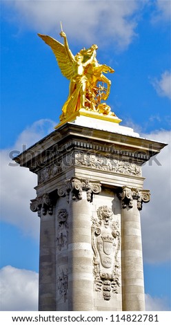 Column with a golden statue on the bridge of Alexandre III, Paris, France