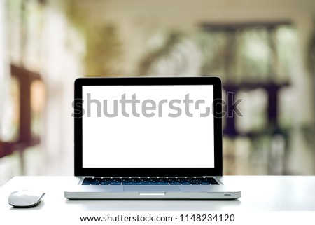 Empty space,White Computer Table and Laptop with blank screen and wireless mouse,Interior home blurred background at light bokeh.