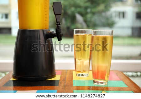 Dispenser and glasses with cold beer on table Royalty-Free Stock Photo #1148274827