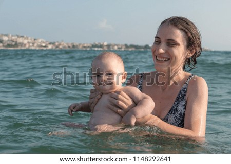 Turkish mother introducing her infant baby girl to sea.