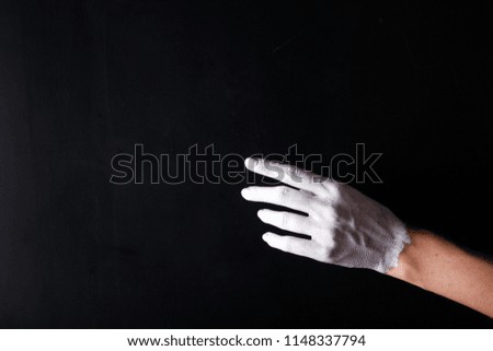 White painted hand on a black background. Abstract. Copy space

