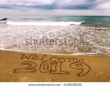 A text welcome 2019 on the floors of the beach