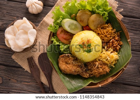 indonesian traditional yellow rice served with banana leaf plate Royalty-Free Stock Photo #1148354843