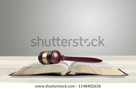 Book and wooden gavel on table