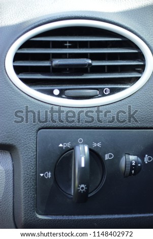 Car Air Conditioner and ventilation. HVAC in car. Oval lattice for air ventilation and conditioner in the automobile. Light control and adjustment of a corner of illumination of headlights from salon