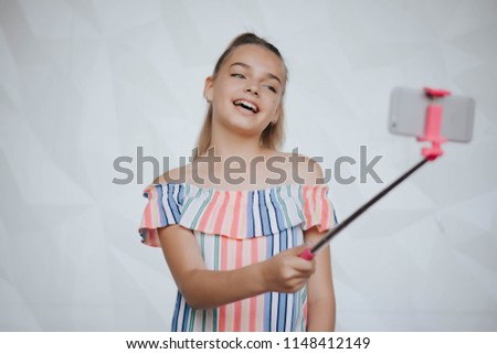 Beautiful young girl is making selfie photo with smartphone. Young hipster woman making selfie. Photo.Smartphone
