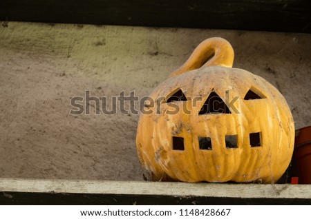 Old Jack O Lantern sitting on a shelf covered in dust