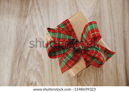 top view of gift box present with red ribbon space wooden background