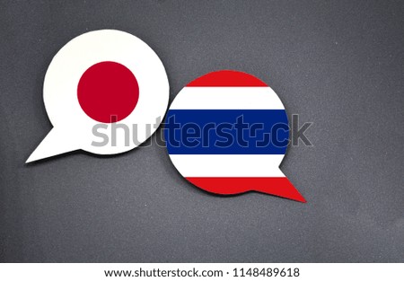Japan and Thailand flags with two speech bubbles on dark gray background