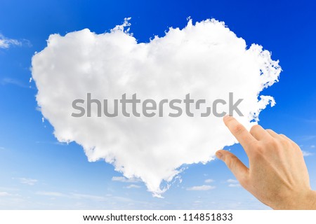 heart shape of cloud and hand point on it over blue sky background