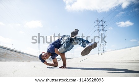 Two bbys ding some stunts - Street artist breakdancing outdrs Royalty-Free Stock Photo #1148528093