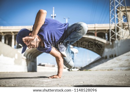 Two bbys ding some stunts - Street artist breakdancing outdrs Royalty-Free Stock Photo #1148528096